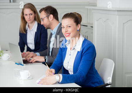 Portrait of a young businesswoman taking notes during the meeting Stock Photo