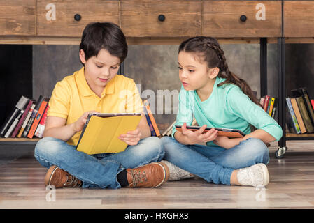 children using digital tablets in library Stock Photo