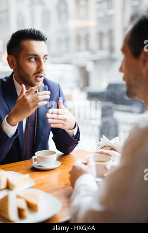 Communication of two businessmen during coffee-break Stock Photo
