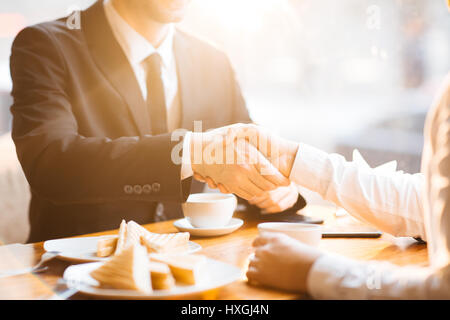 Handshake of businessmen during lunch break Stock Photo