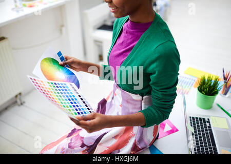 Girl with color palettes sitting on workplace Stock Photo