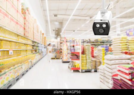 Modern security camera on monitoring the supermarket with blurred blackground Stock Photo