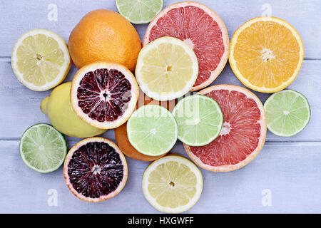 Variety of citrus fruits (orange, blood oranges, lemons, grapefruits, and limes) over a blue wood table top rustic background. Image shot from overhea Stock Photo