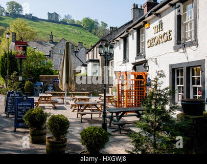 The George Inn at Castleton in the derbyshire Peak District with Peveril Castle on the hill behind the village Stock Photo