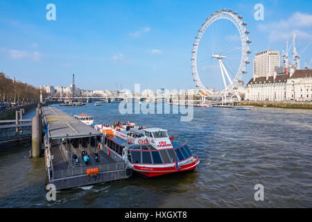 Cruise boat on Westminster pier on the River Thames with the London Eye in the background, London England United Kingdom UK Stock Photo