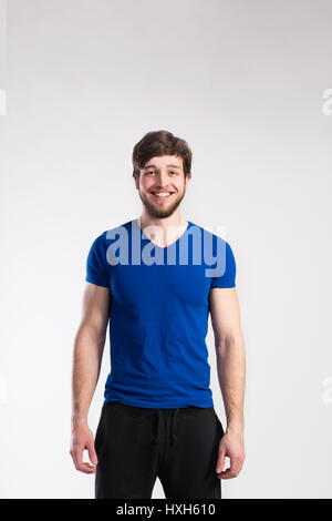 Handsome fitness man in blue t-shirt, studio shot. Stock Photo