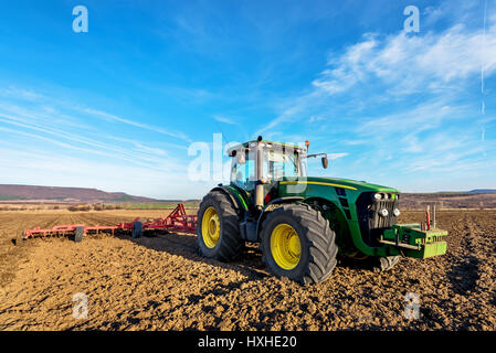 Varna, Bulgaria - March 5, 2017 Ploughing a field with John Deere tractor. John Deere was manufactured in 1995-1999 and it has JD 7.6L or 8.1L 6-cyl d Stock Photo