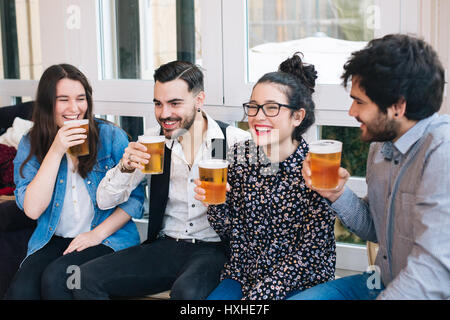 Young group of friends having fun in a bar drinking beer Stock Photo