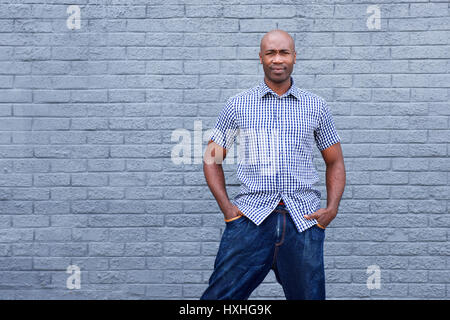 Portrait of handsome african man standing against gray background Stock Photo