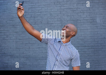 Side portrait of an african american man taking a selfie with mobile phone Stock Photo