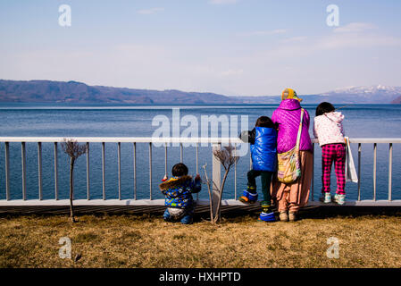 A family looking out the toya volcanic lake Hokaido Japan Stock Photo