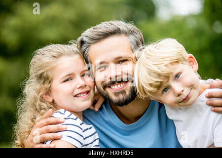 Children with father having fun and making funny faces Stock Photo