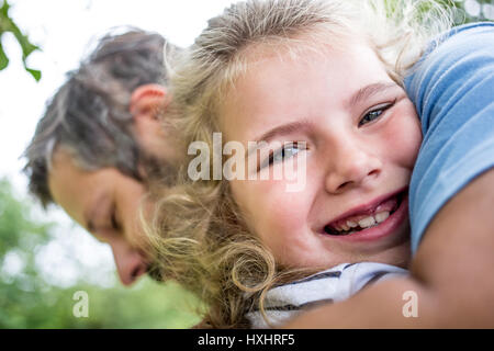 Happy girl hugs dad with love in the park Stock Photo