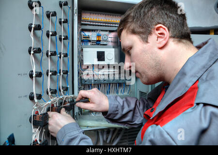 St. Petersburg, Russia - March 5, 2013: Mechanical Engineer doing upgrade equipment electrical switchboard. Stock Photo