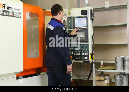 St. Petersburg, Russia - September 3, 2015: The operator controls the CNC milling machines using control panel with display. Stock Photo