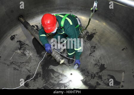 St. Petersburg, Russia - August 9, 2016:  Internal industrial boiler inspection, the worker is inside the boiler during its repair. Stock Photo