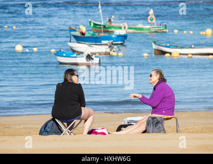 Two elderly women talking on beach following morning swim Stock Photo