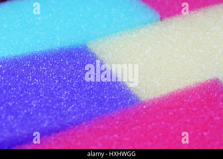 Cleaning kitchen sponge texture as background. Colorful yellow pink green purple blue multicolor sponges. Close up macro about sponges. Sponge pattern Stock Photo