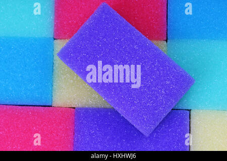 Cleaning kitchen sponge texture as background. Colorful yellow pink green purple blue multicolor sponges. Close up macro about sponges. Sponge pattern Stock Photo