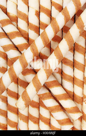 Ice cream wafer sticks as background. Wafer biscuit swirled stick texture. Wafers pattern. Wafer curls. Stock Photo