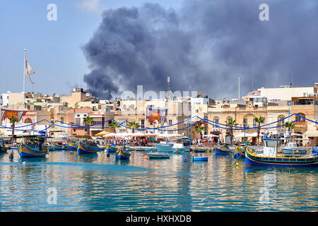 MARSAXLOKK, MALTA - AUGUST 1, 2015:  The view of the smoke from the fire over the Marsaxlokk fishing village, Malta Stock Photo