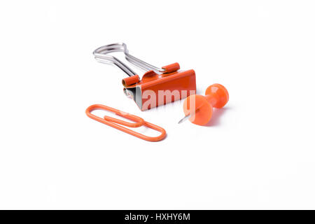 Orange pushpin and paperclips on a white background. Stock Photo