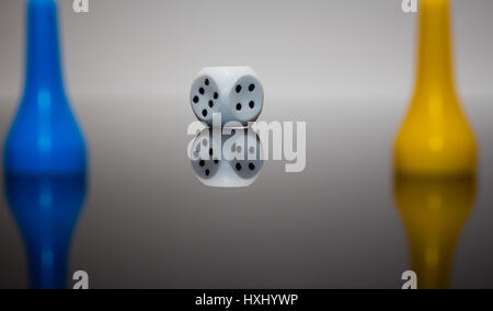 Rolling red dice over black grey background Stock Photo