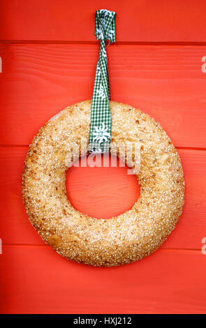 A beautiful round bread on a red background photographed in close-up Stock Photo