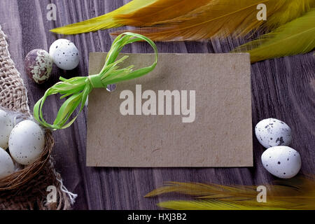 Easter Background with easter eggs burlap cloth yellow feathers green ribbon and space for text Stock Photo