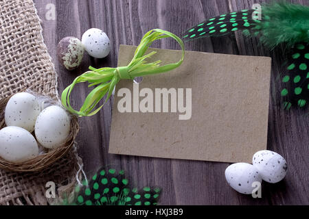 Easter Background with easter eggs burlap cloth green feathers green ribbon and space for text Stock Photo