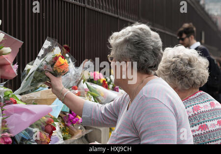 London, UK. 28th March 2017. Members of the public place flowers on the railings of the House of Commons following the terror attack Credit: Ian Davidson/Alamy Live News Stock Photo