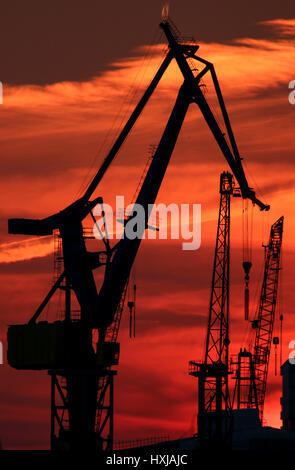 Hamburg, Germany. 28th Mar, 2017. The sun sets behind ships moored at the harbour in Hamburg, Germany, 28 March 2017. Photo: Axel Heimken/dpa/Alamy Live News Stock Photo