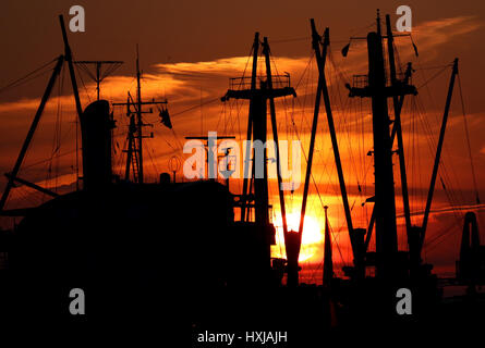 Hamburg, Germany. 28th Mar, 2017. The sun sets behind ships moored at the harbour in Hamburg, Germany, 28 March 2017. Photo: Axel Heimken/dpa/Alamy Live News Stock Photo