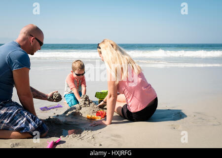 Family of 3 playing in the sand on the beach, Riviera Nayarit, Mexico Stock Photo