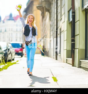 Happy tourist girl with map walking on city street Stock Photo