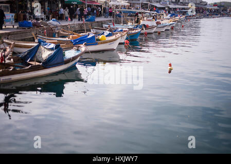 Izmir, Turkey - March 26, 2017: Phokaia port, fisher boats and crowded people on the scene. Stock Photo