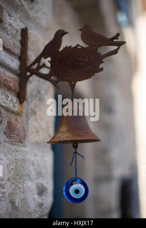 Rusted metal birds and amulet doorbell. Stock Photo