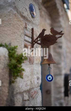 Rusted metal birds and amulet doorbell. Stock Photo