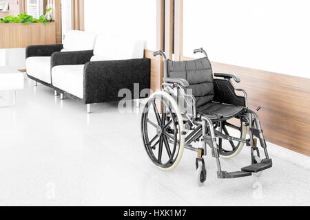 Empty wheelchair parked in hospital hallway Stock Photo