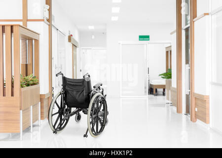 Empty wheelchair parked in hospital hallway Stock Photo