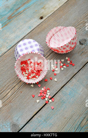 Color candy hearts with cupcake cases on wooden background Stock Photo