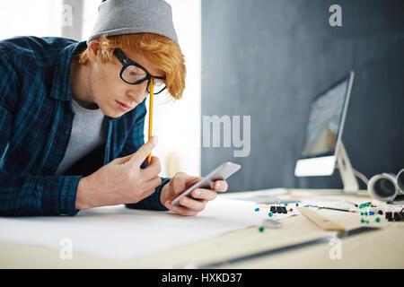 Young Ginger Man Using Smartphone for Work Stock Photo