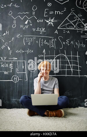 Smart Student Using Laptop and Phone Stock Photo