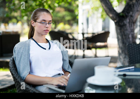 Concentrated on work in outdoor cafe Stock Photo