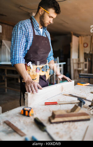Skillful carpenter wrapped up in work Stock Photo
