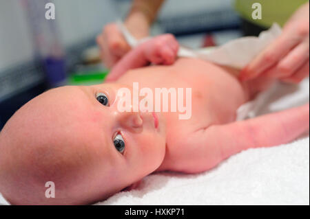 Mom puts a diaper on the baby Stock Photo