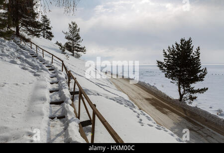 Snow-covered staircase on the shore of winter lake Baikal Stock Photo