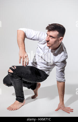 The young man dancing on gray Stock Photo