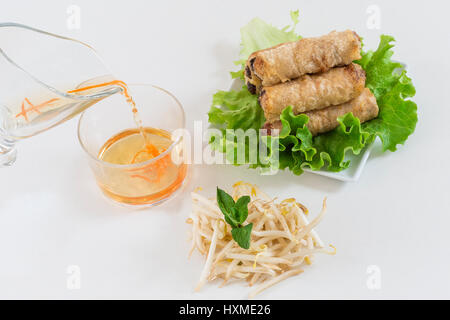 Asian spring rolls fried on a plate close-up and sauce on white Stock Photo