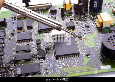 computer micro circuit board with iron soldering and tin wire in electronic laboratory Stock Photo